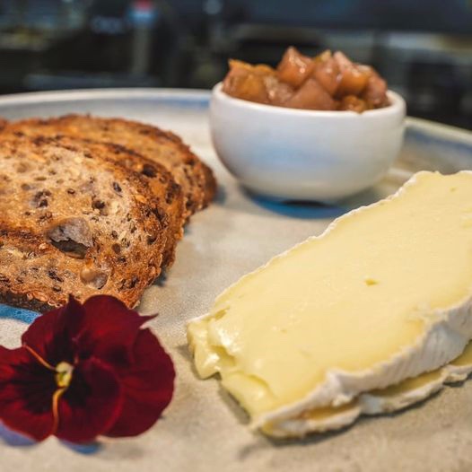Brie with pear chutney and sourdough on a white plate